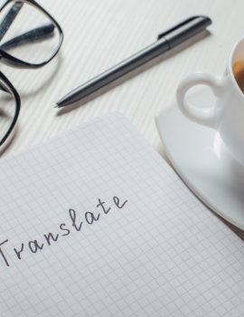close up of coffee and notepad with word translate on workplace